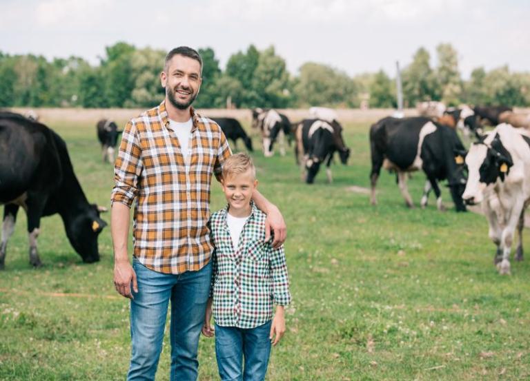 ojciec z synem na pastwisku z krowami